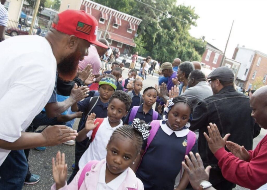 Community members giving high fives to students at back to school event