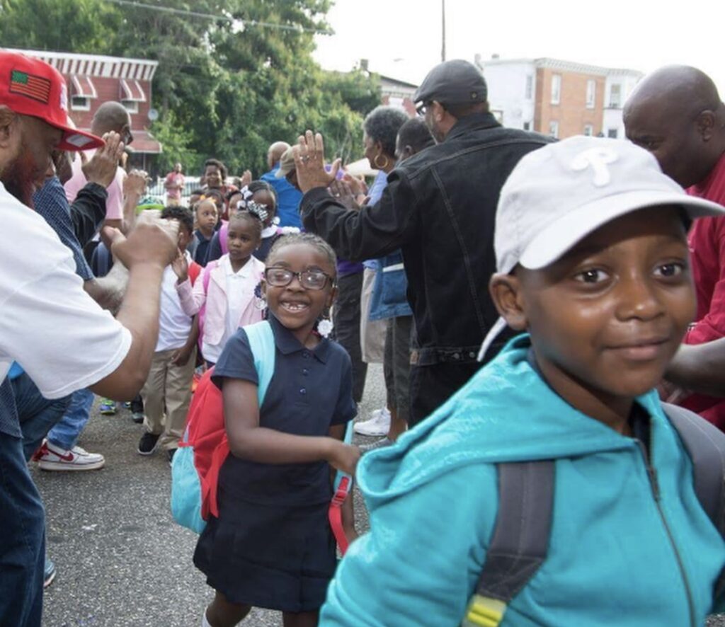 Students walking through high five line at back to school celebration